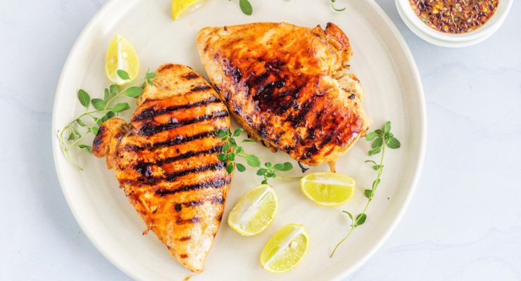 Grilled Balsamic Chicken Breast on a plate with lemon and oregano