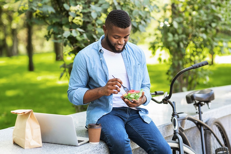man eating salad outside