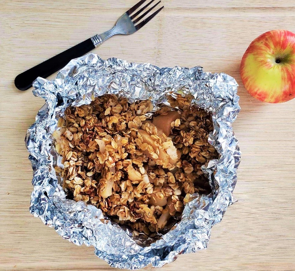 Camping Apple Crisp in foil with a fork