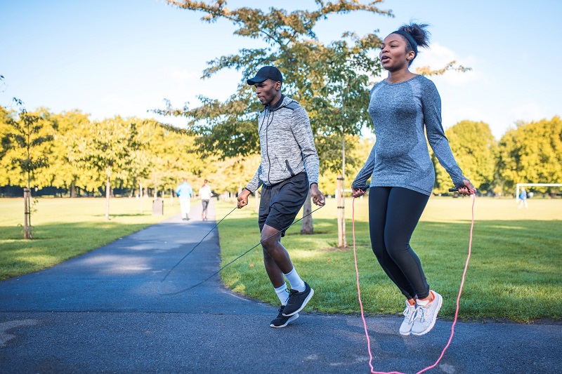 Couple jumping rope as part of their outdoor workout to lose weight