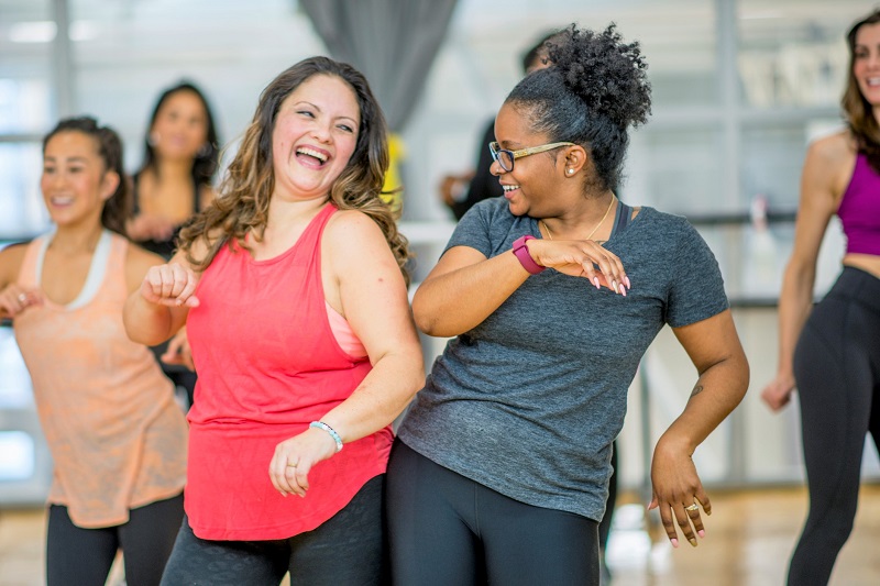Happy women at group dance workout class to lose weight