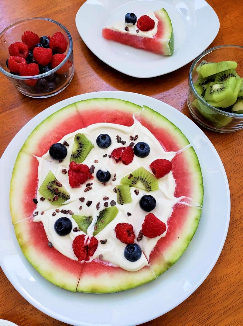 Watermelon Pizza topped with Greek yogurt, berries and cacao nibs