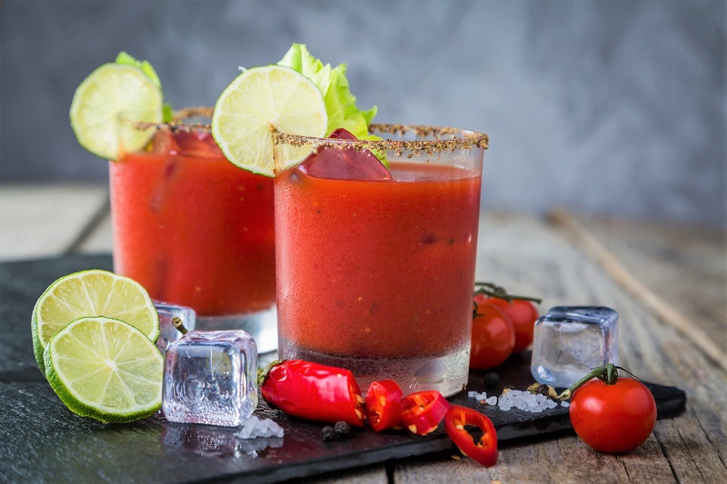 A pair of Bloody Marys with fruit and vegetable fixings
