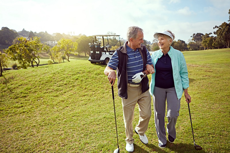 Senior couple walking through a golf course