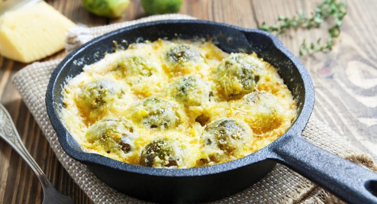 creamed brussels sprouts with cheese in a pan