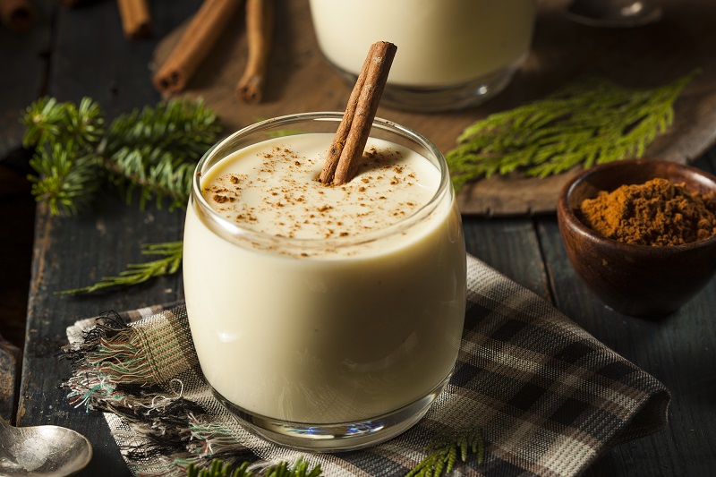 A glass of creamy egg nog topped with cinnamon