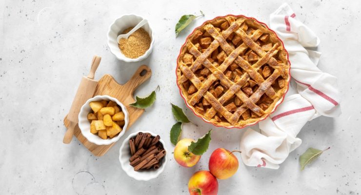Scrumptious fall baking ingredients surrounding a healthy apple pie.