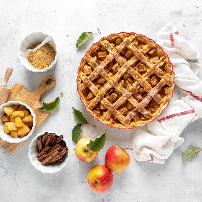 Scrumptious fall baking ingredients surrounding a healthy apple pie.