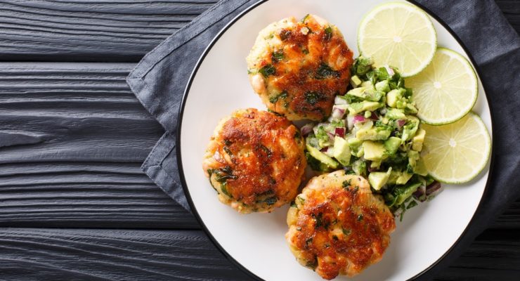 air fryer shrimp cakes with avocado salad and sliced limes