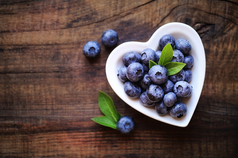 Healthy blueberries in a heart-shaped bowl