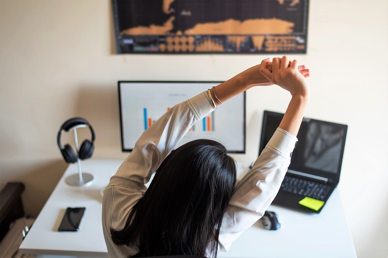 Person stretching their arms at their desk