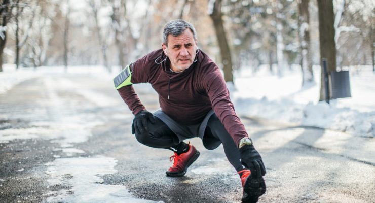 Man stretching hamstring in the snow