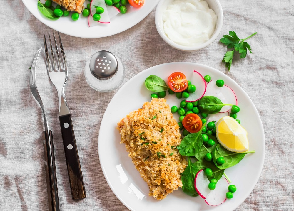 Pistachio crusted halibut on a plate with salad