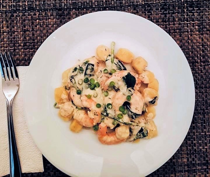 Garlic Parmesan Shrimp Gnocchi on a plate with peas and spinach