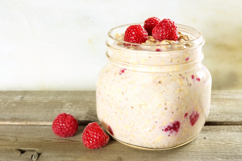 berry cheesecake overnight oats in a jar with raspberries