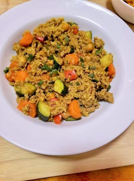 Curried Turkey with rice and vegetables in a white bowl