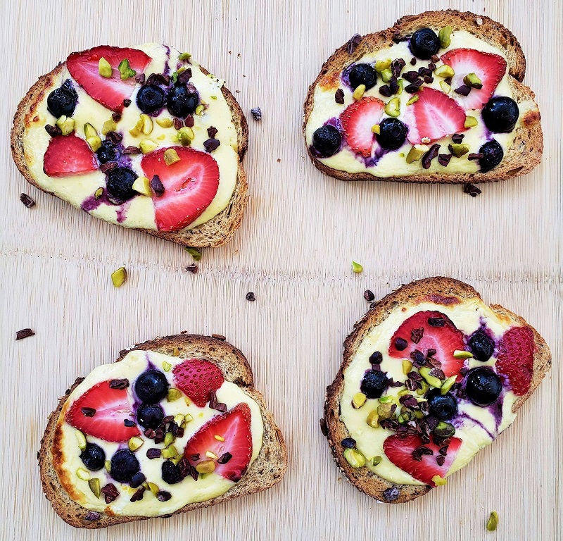 4 pieces of custard toast with yogurt and berries on top of them
