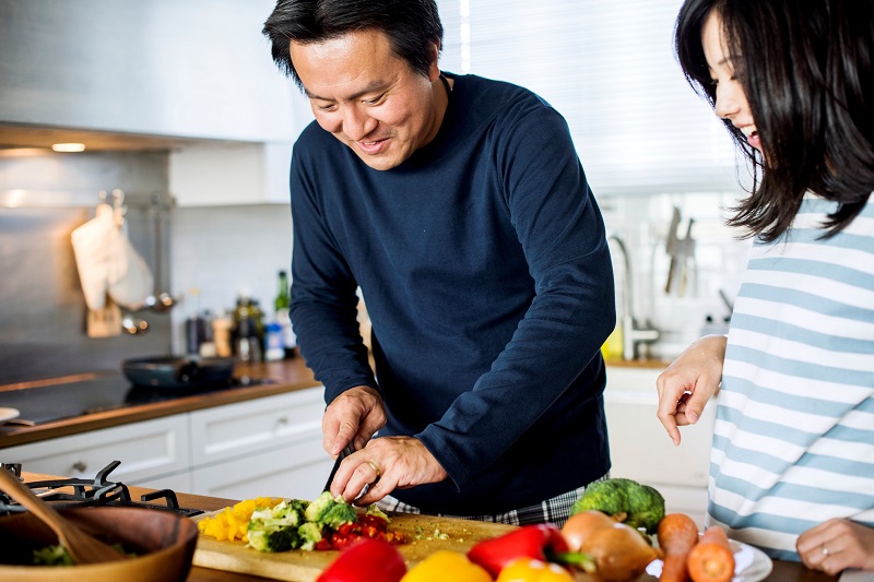 Man and woman chopping vegetable