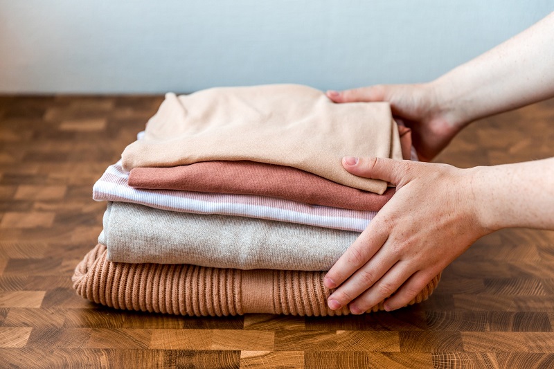 Stack of shirts and sweaters on a wooden table