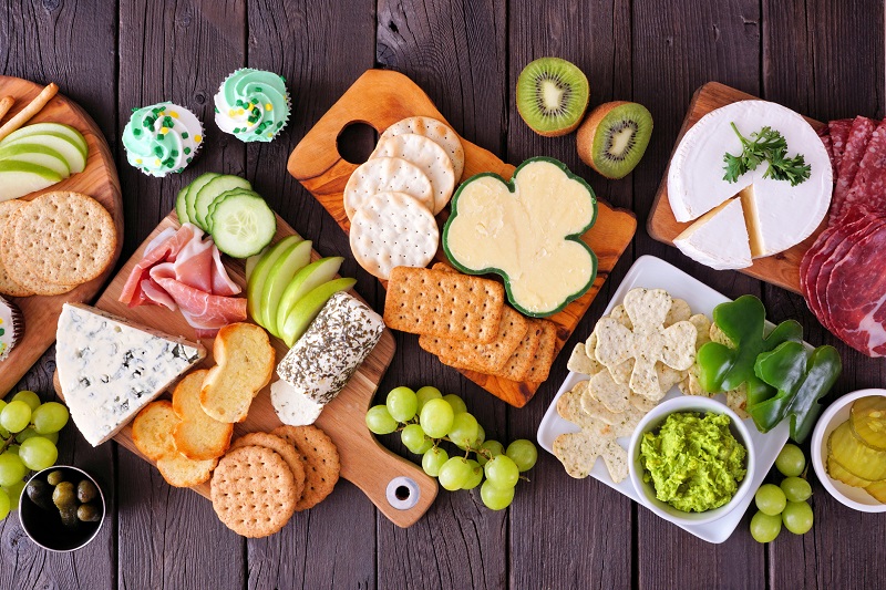 Different collection of Irish shamrock snacks on a brown table