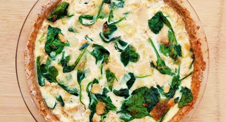 Ham and spinach quiche on a clear plate