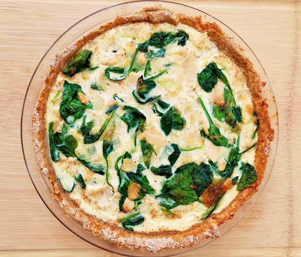 Ham and spinach quiche on a clear plate