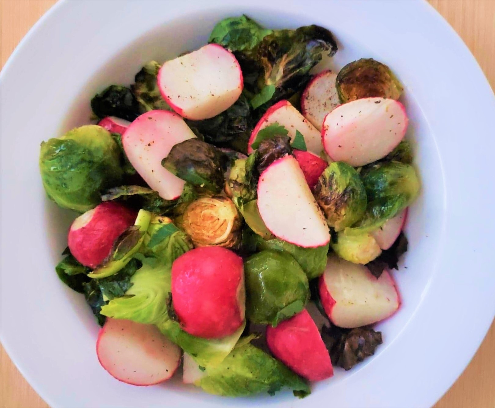 Roasted Radishes and Brussels Sprouts in a white serving bowl