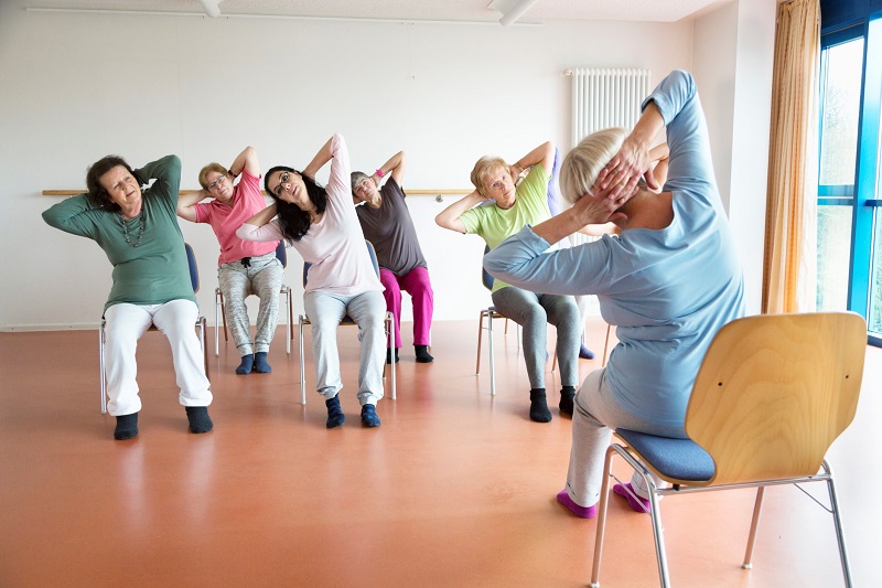 Room full of people in a stretching class