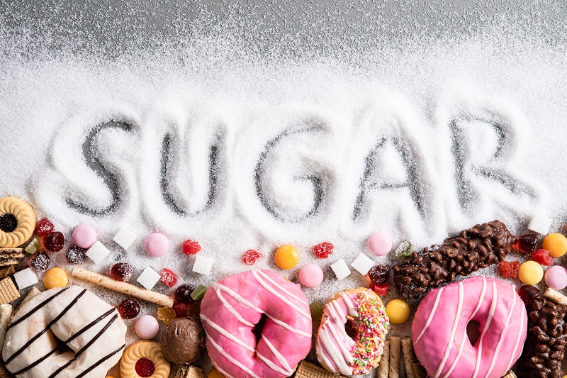 The word sugar spelled out with an assortment of donuts and candy