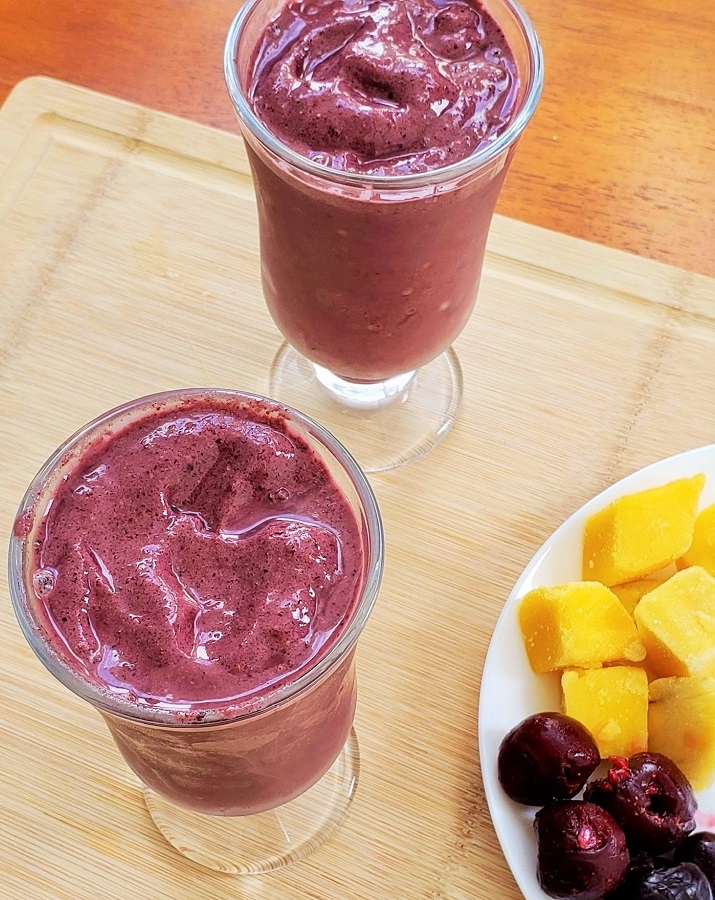 two Acai Smoothies with frozen mango and cherries