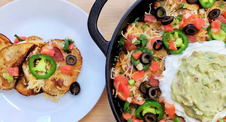 Irish pub potato nachos in a skillet with nacho toppings