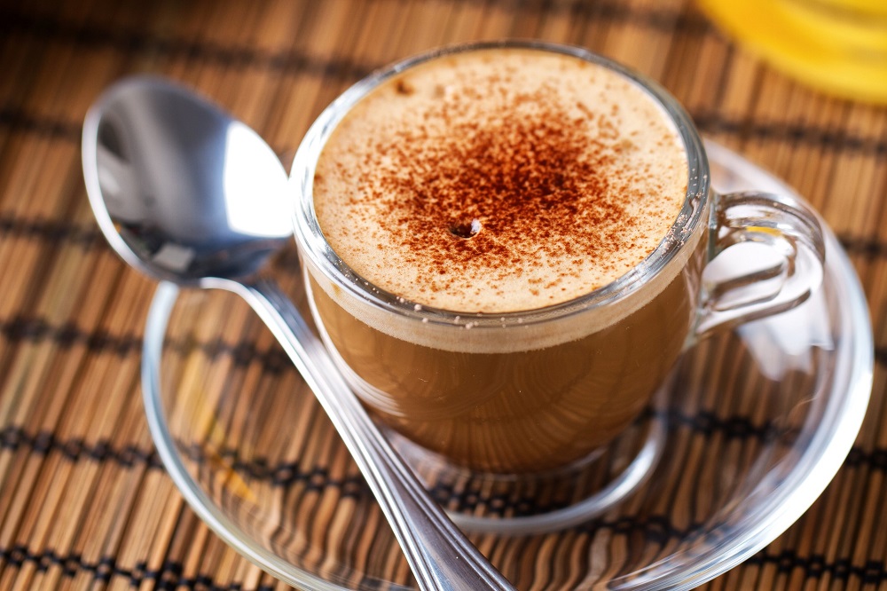 early grey tea latte with cinnamon in a glass mug