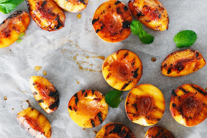 grilled peaches served with mint leaves
