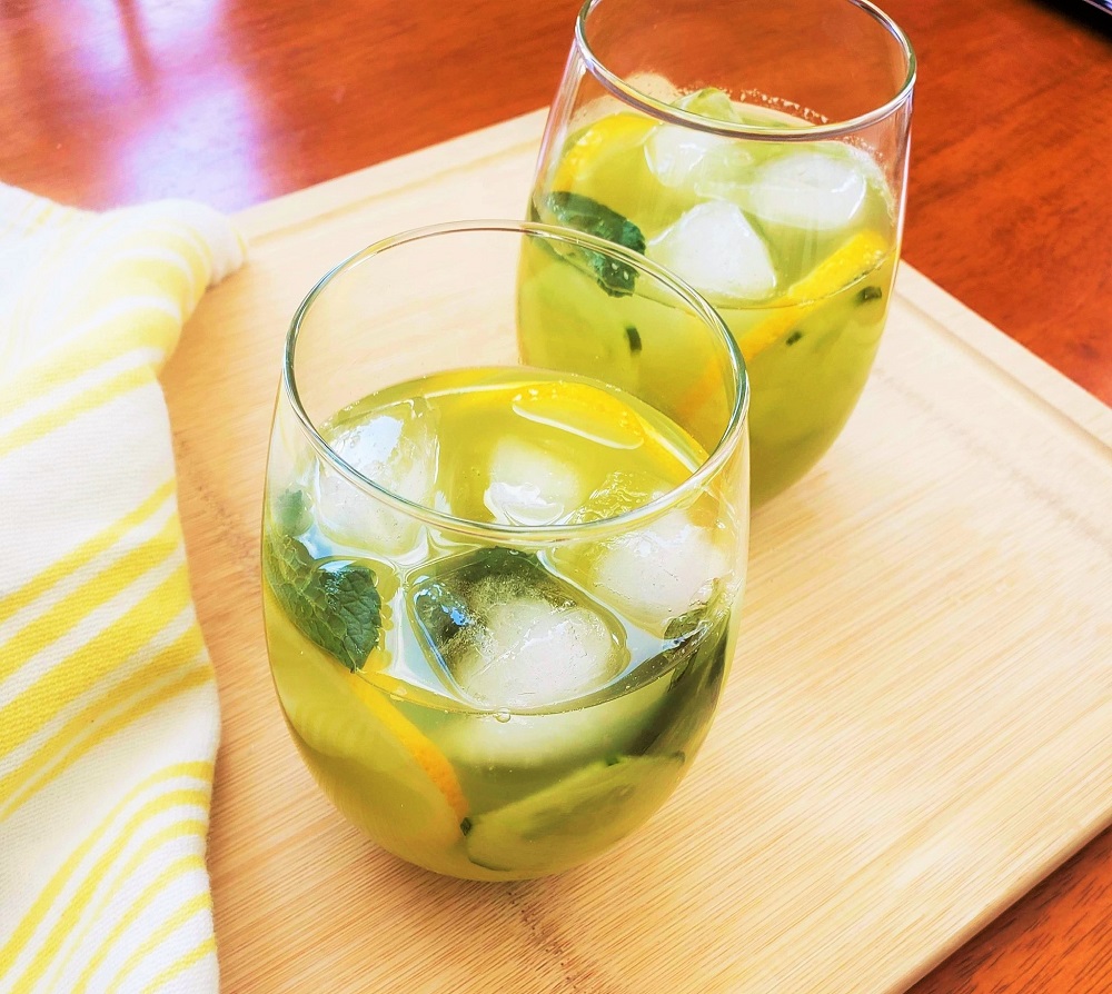 lemon drink with fresh mint and ice in two glasses on a cutting board