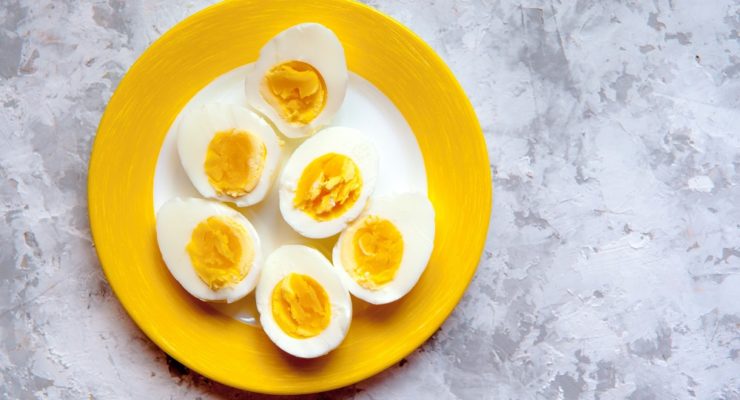 sliced hard boiled eggs on a yellow and white plate