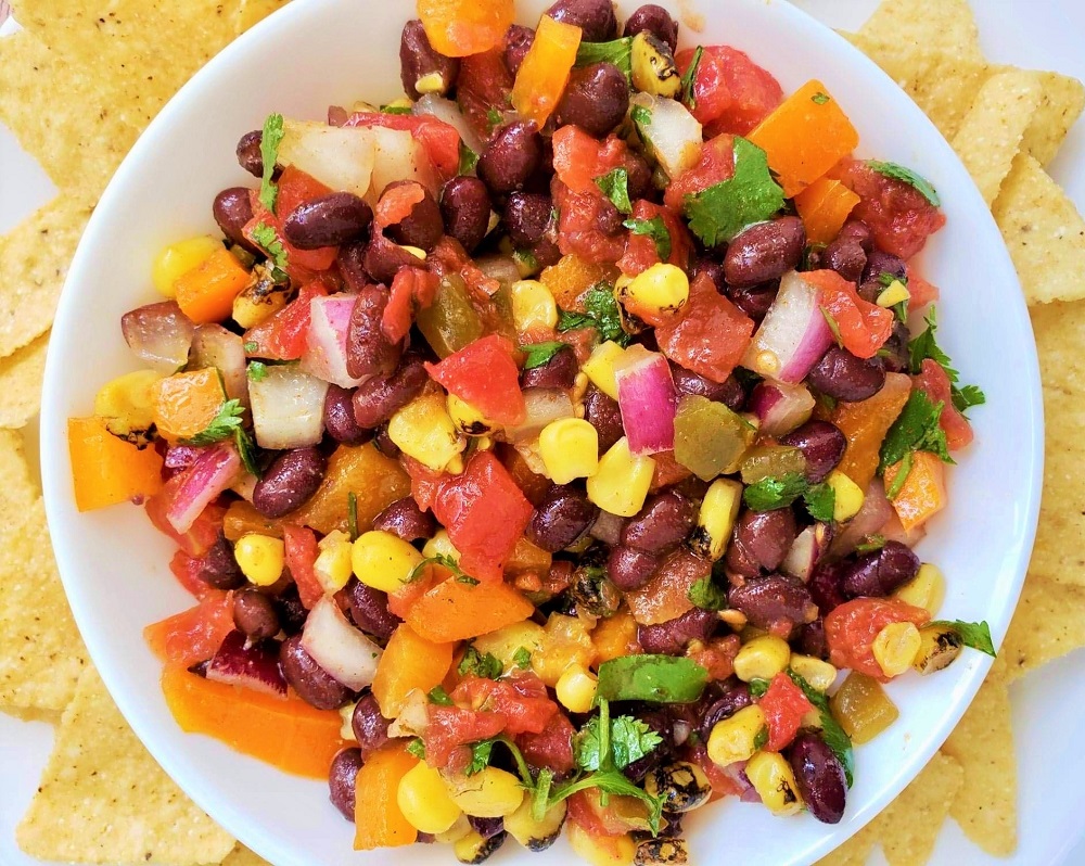 Cowboy Caviar dip in a white bowl with tortilla chips