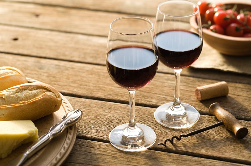Two glasses of red wine on a wooden table