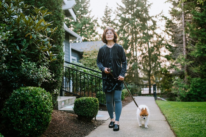 Woman Walks Her Dog In Home Neighborhood