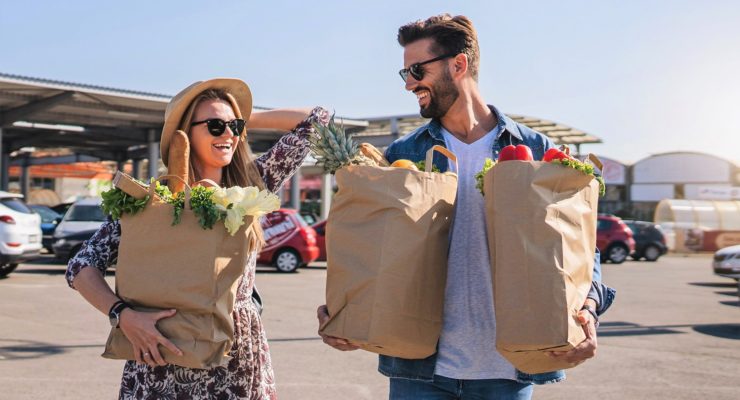Cheerful couple leaving supermarket after shopping