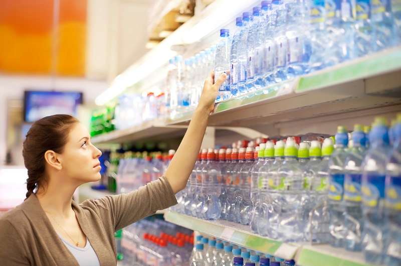 woman buys a water bottle in shop