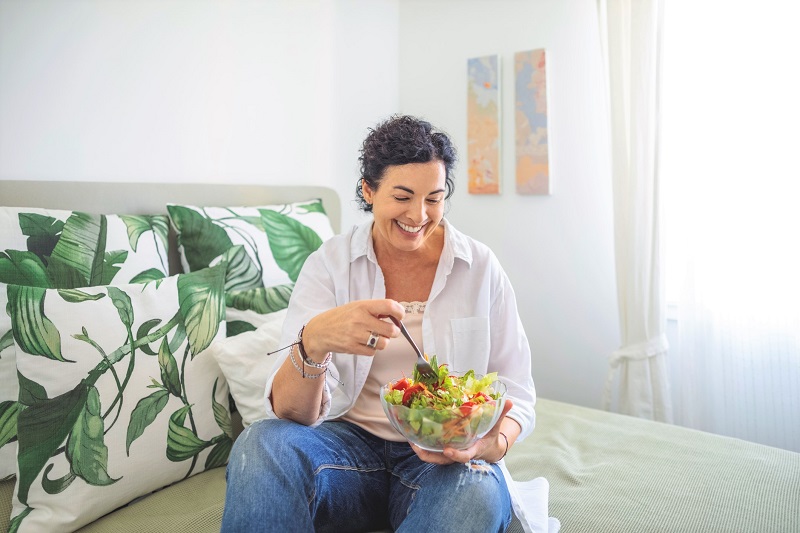 woman eating a healthy salad at home