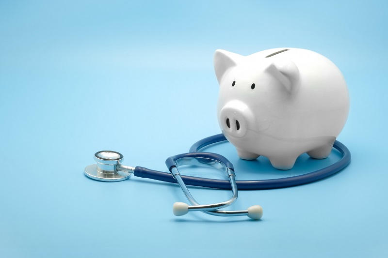 Piggy bank with stethoscope isolated on light blue background