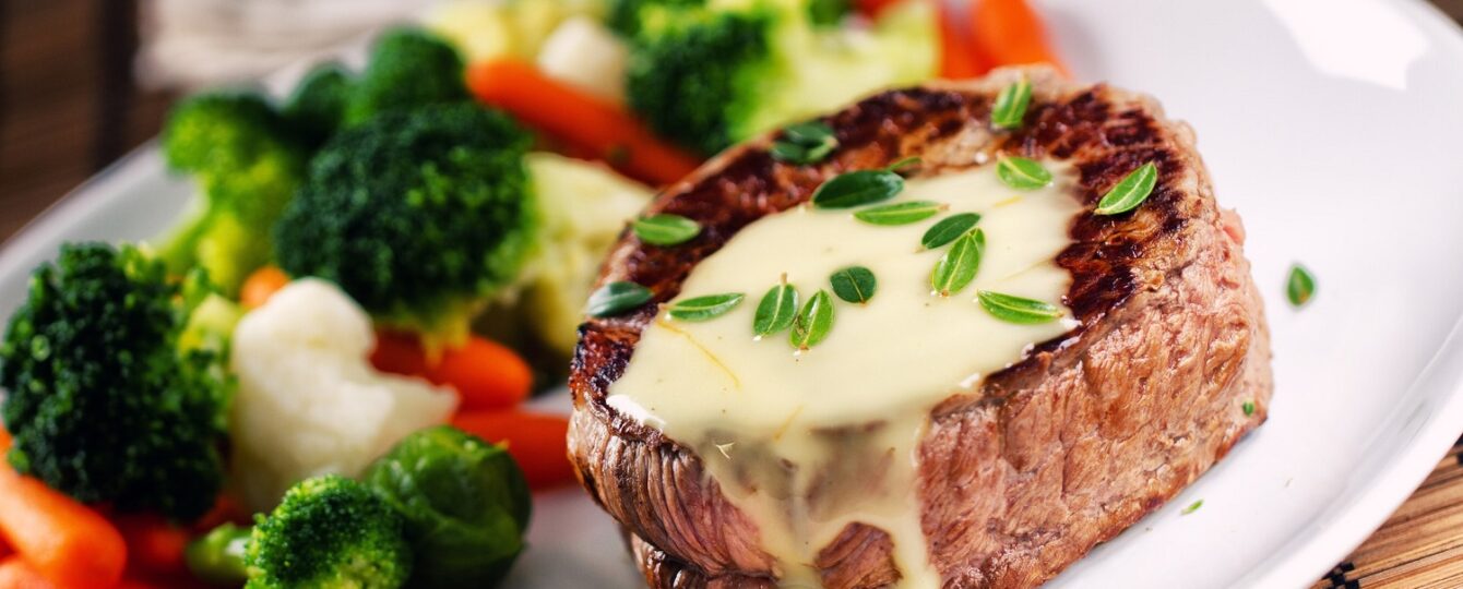 filet mignon steak with parmesan cream sauce and side of vegetables