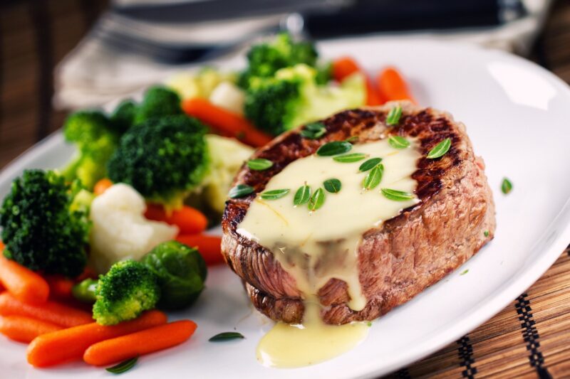 filet mignon steak with parmesan cream sauce and side of vegetables