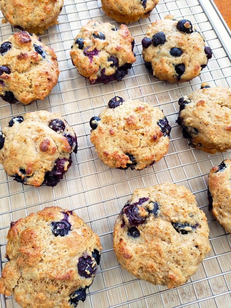 healthy whole wheat blueberry muffins on a wire rack cooling