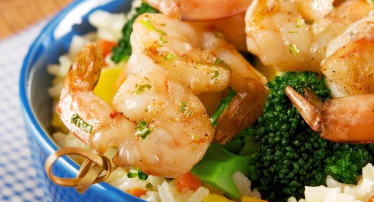 honey garlic shrimp and rice in a bowl with broccoli and bell peppers