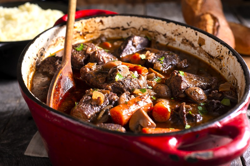 beef stew cooking in a large red pot