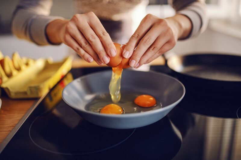 Woman cooking an egg