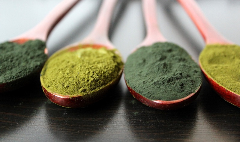 different green powders on spoons