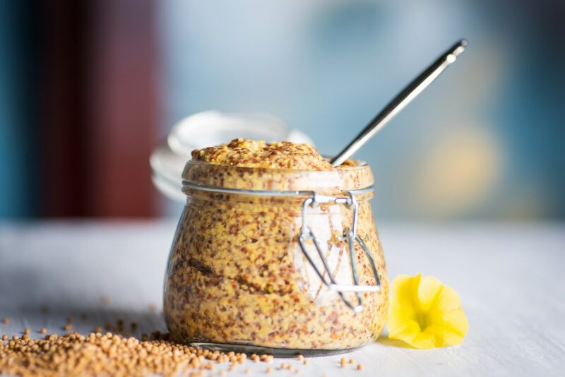 Whole grain mustard in a jar on a table